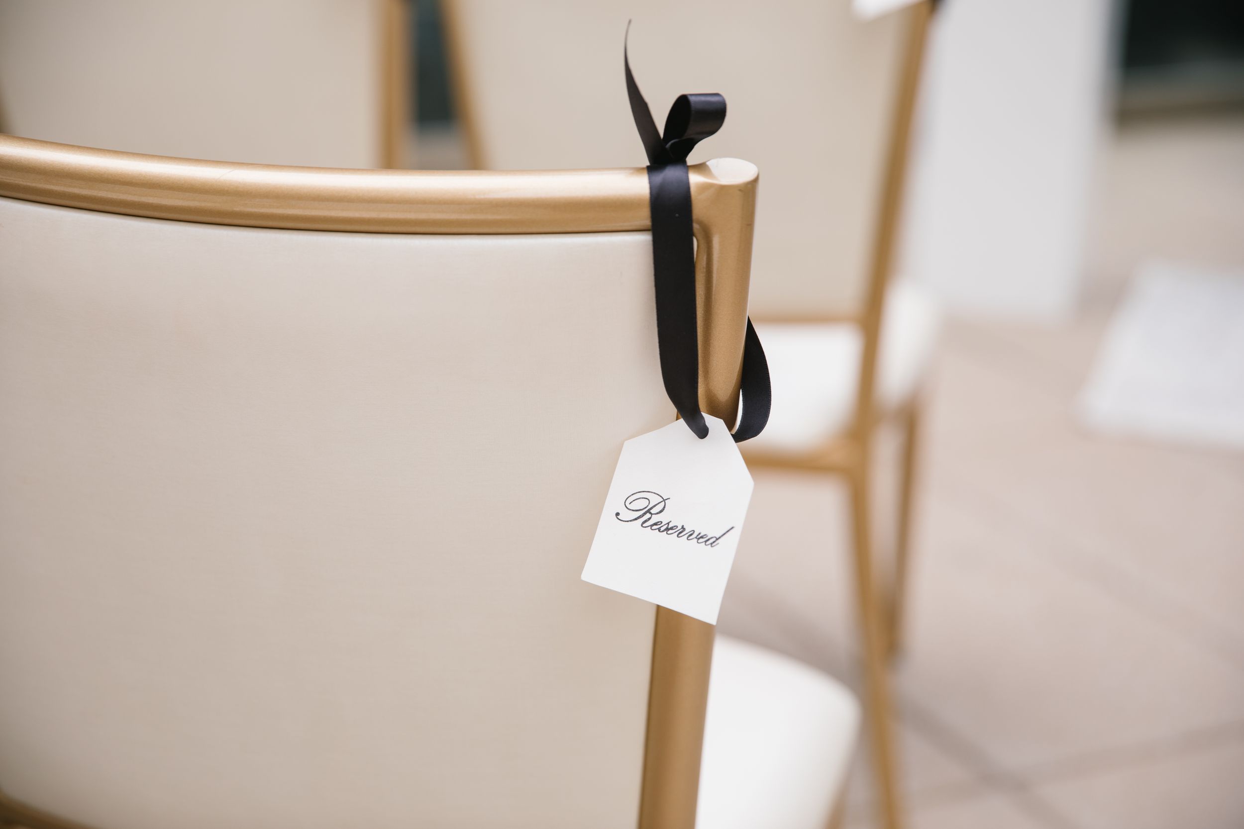 close up of reserved sign hung on chair with black ribbon