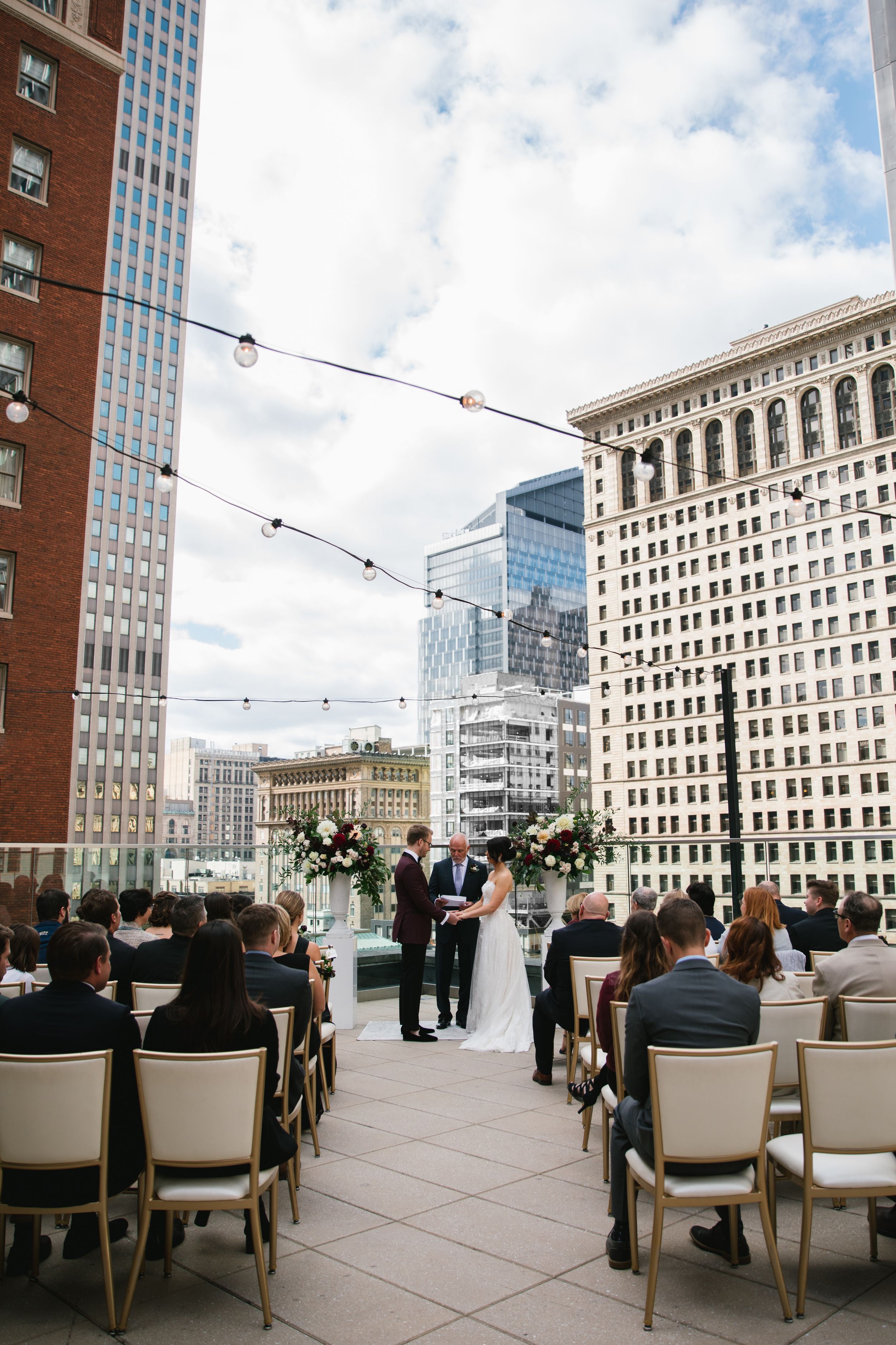 bride and groom holding hands during rooftop ceremony toronto downtown big city