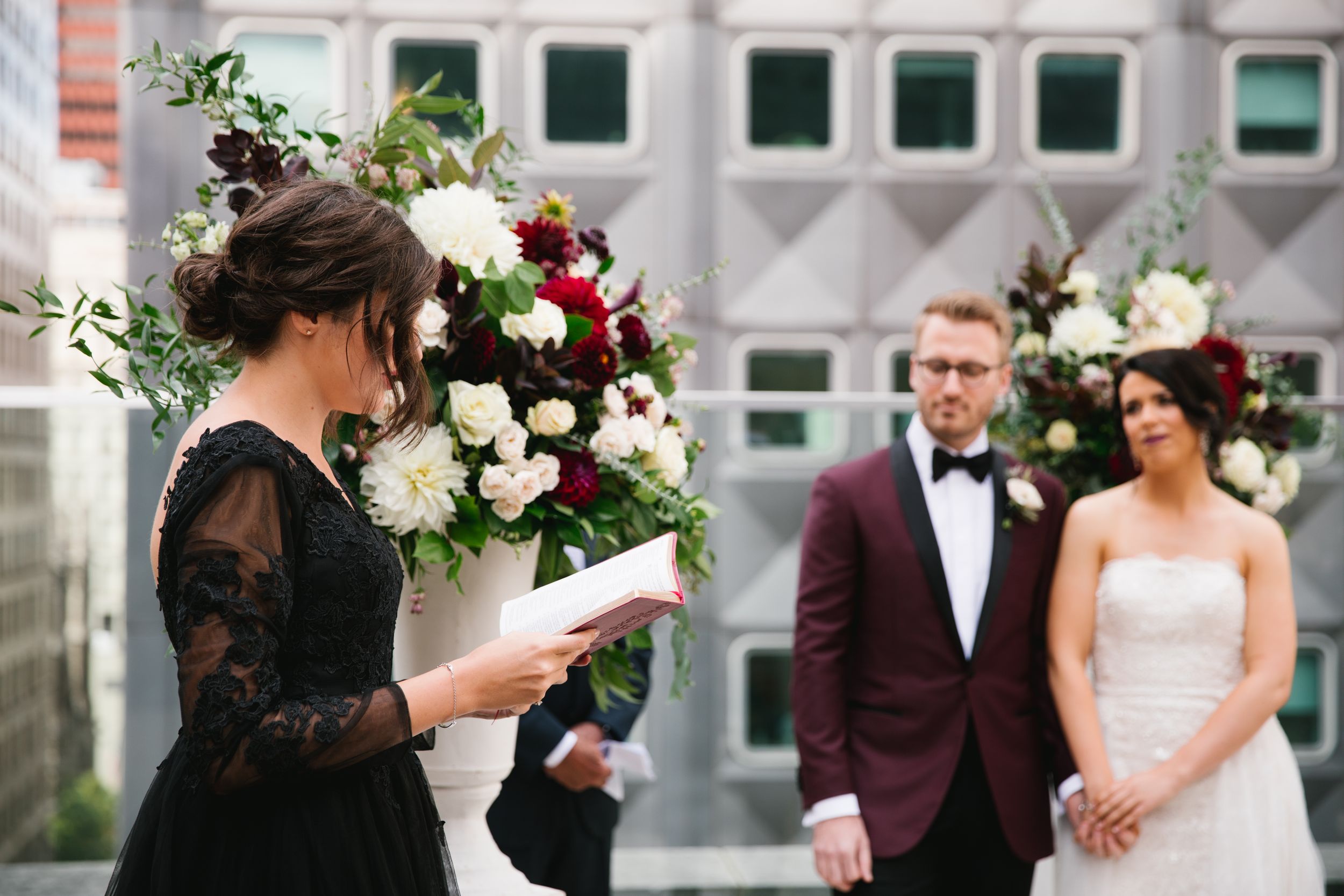 bridesmaid reads while bride and groom look on and hold hands during ceremony