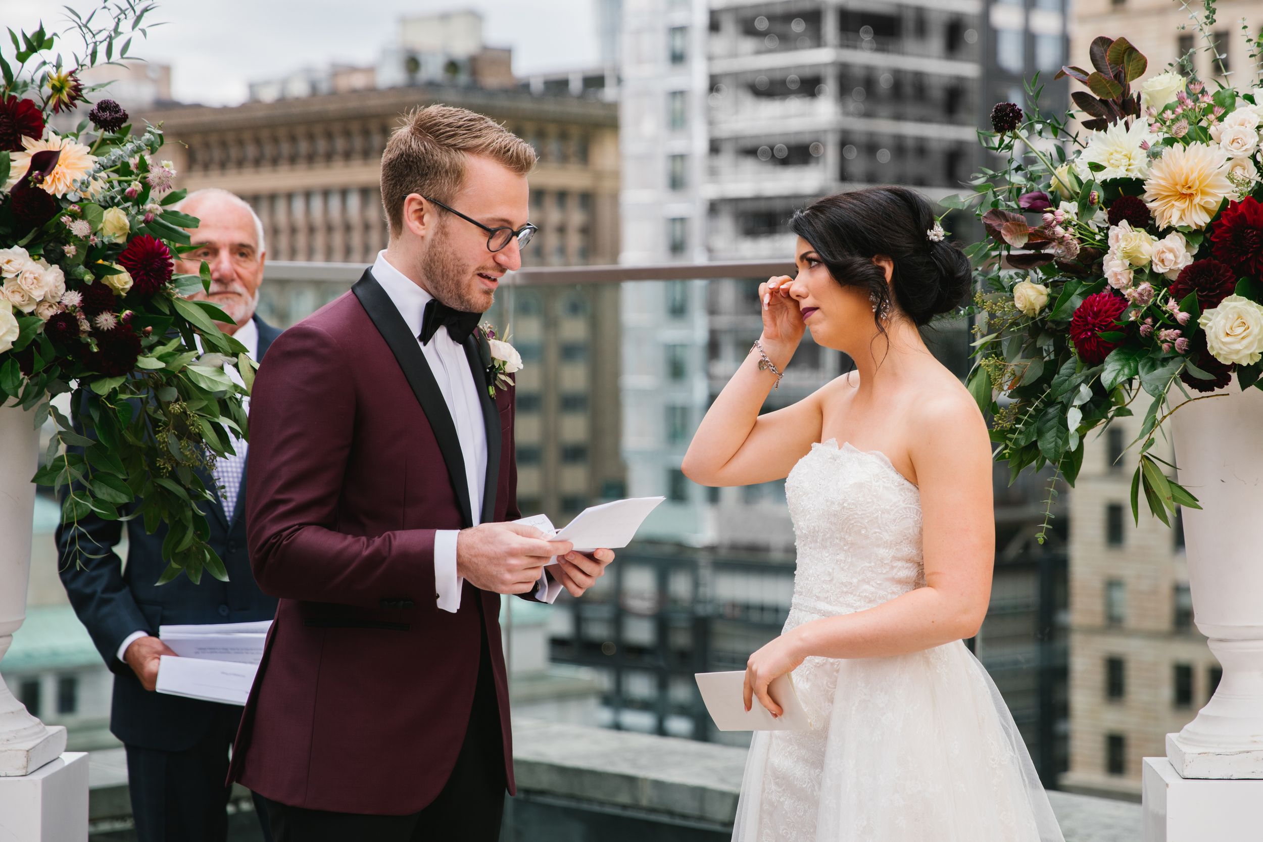bride wipes away tear crying during grooms vows rooftop ceremony wedding