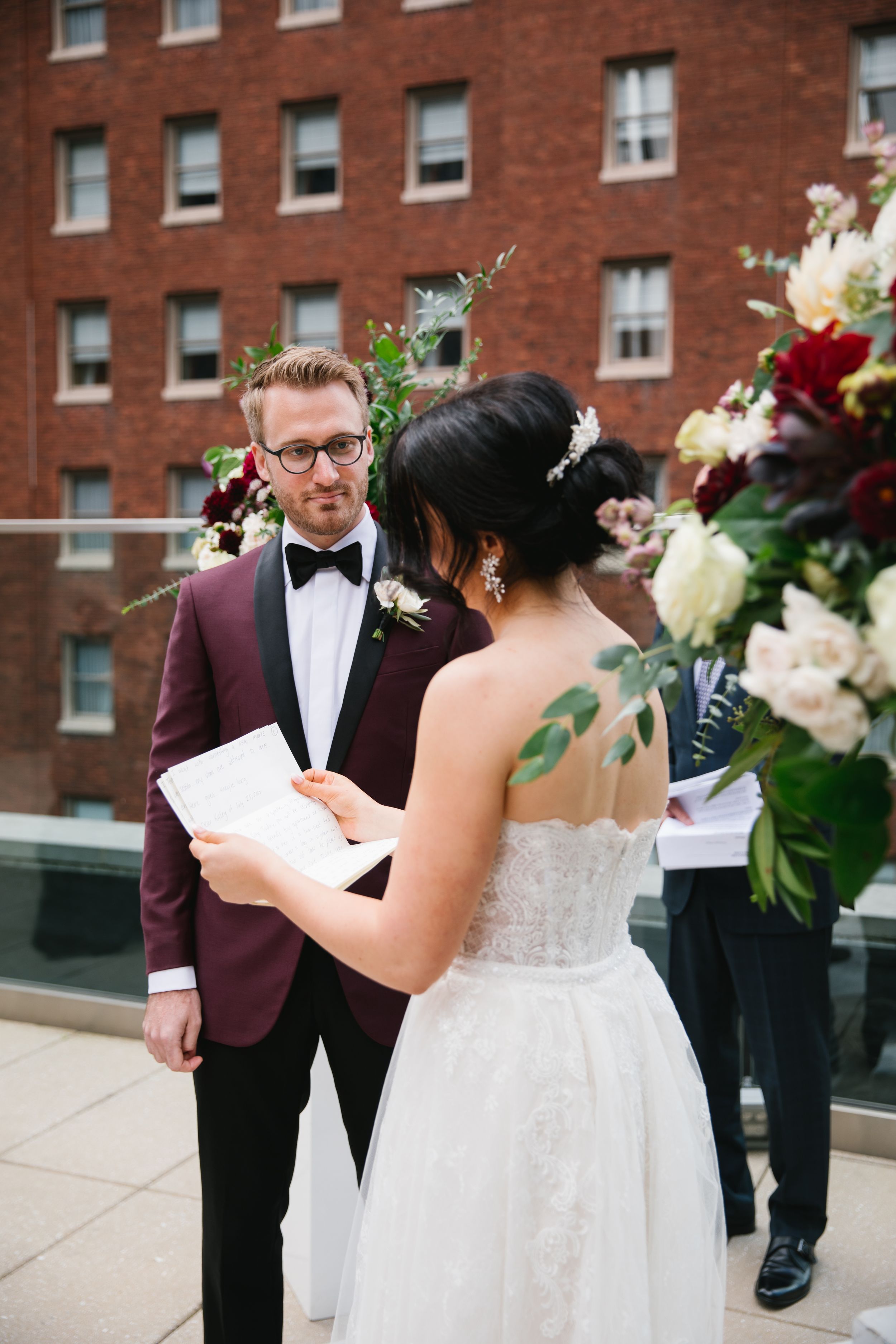 bride reads her vows to groom during rooftop ceremony