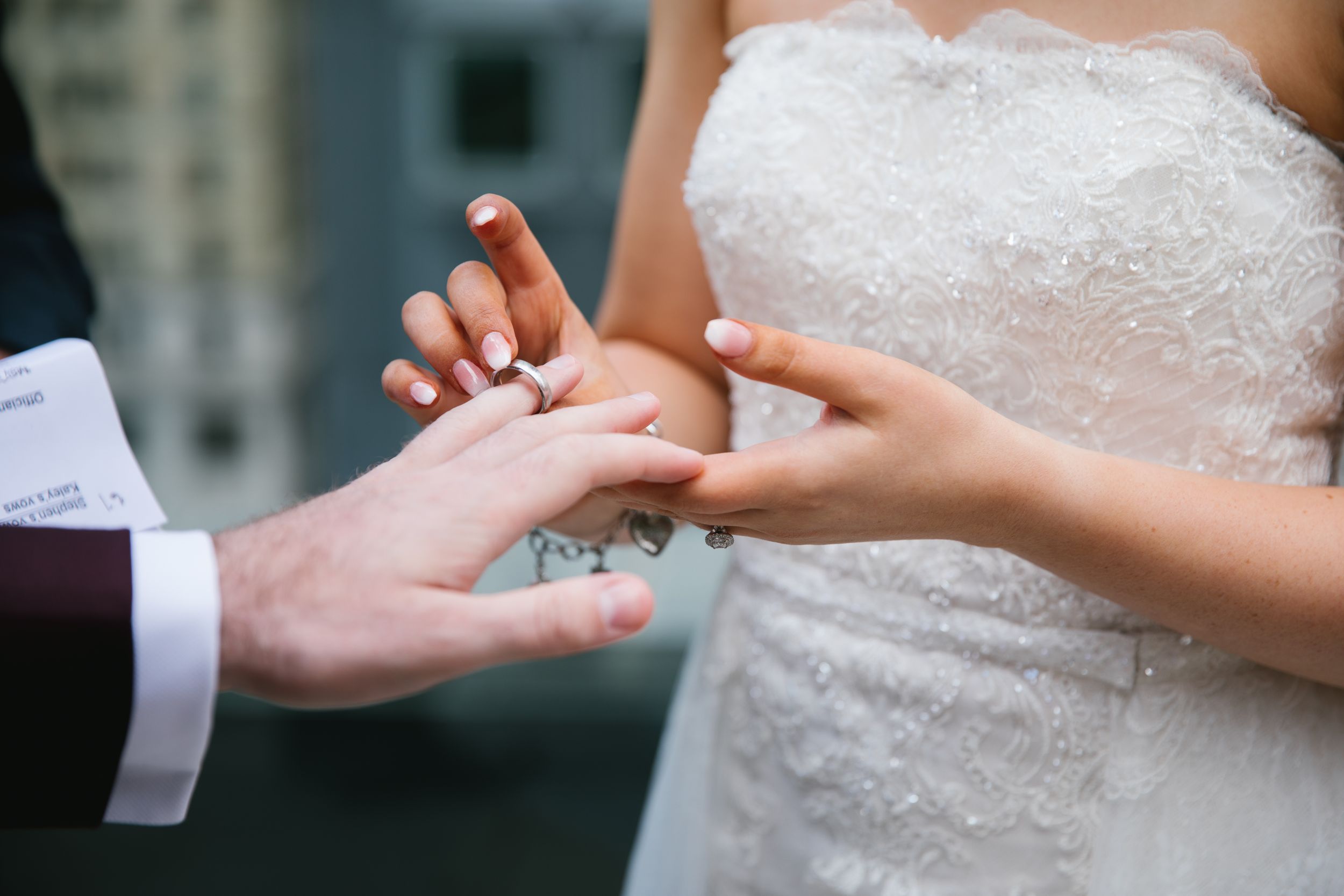 close up of exchanging rings during rooftop ceremony