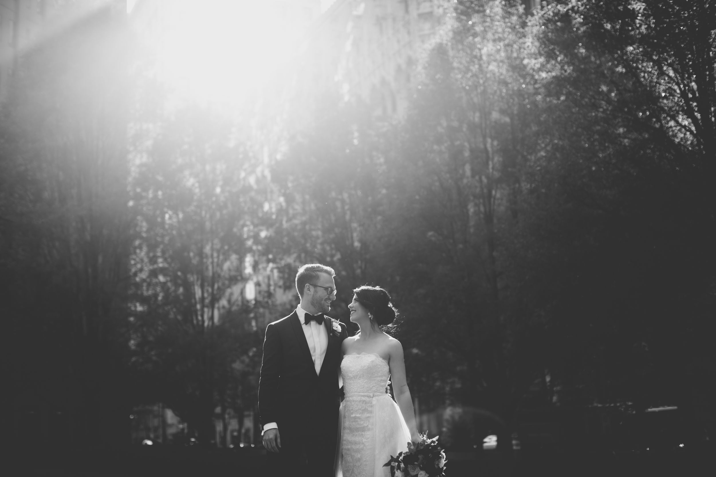 black and white photo of bride and groom with the sun shining on them