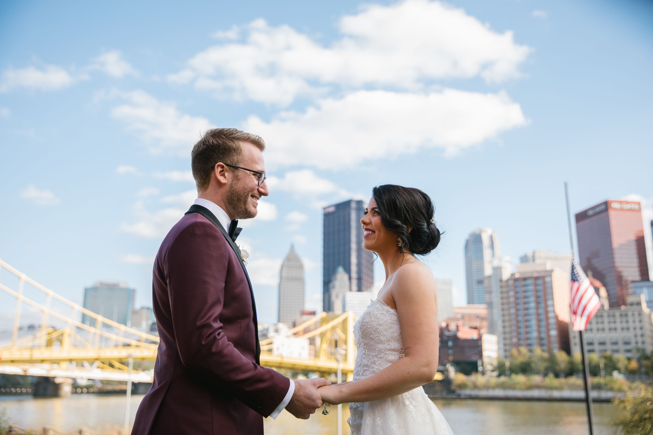 close up of bride and groom holding hands with pittsburgh city behind them