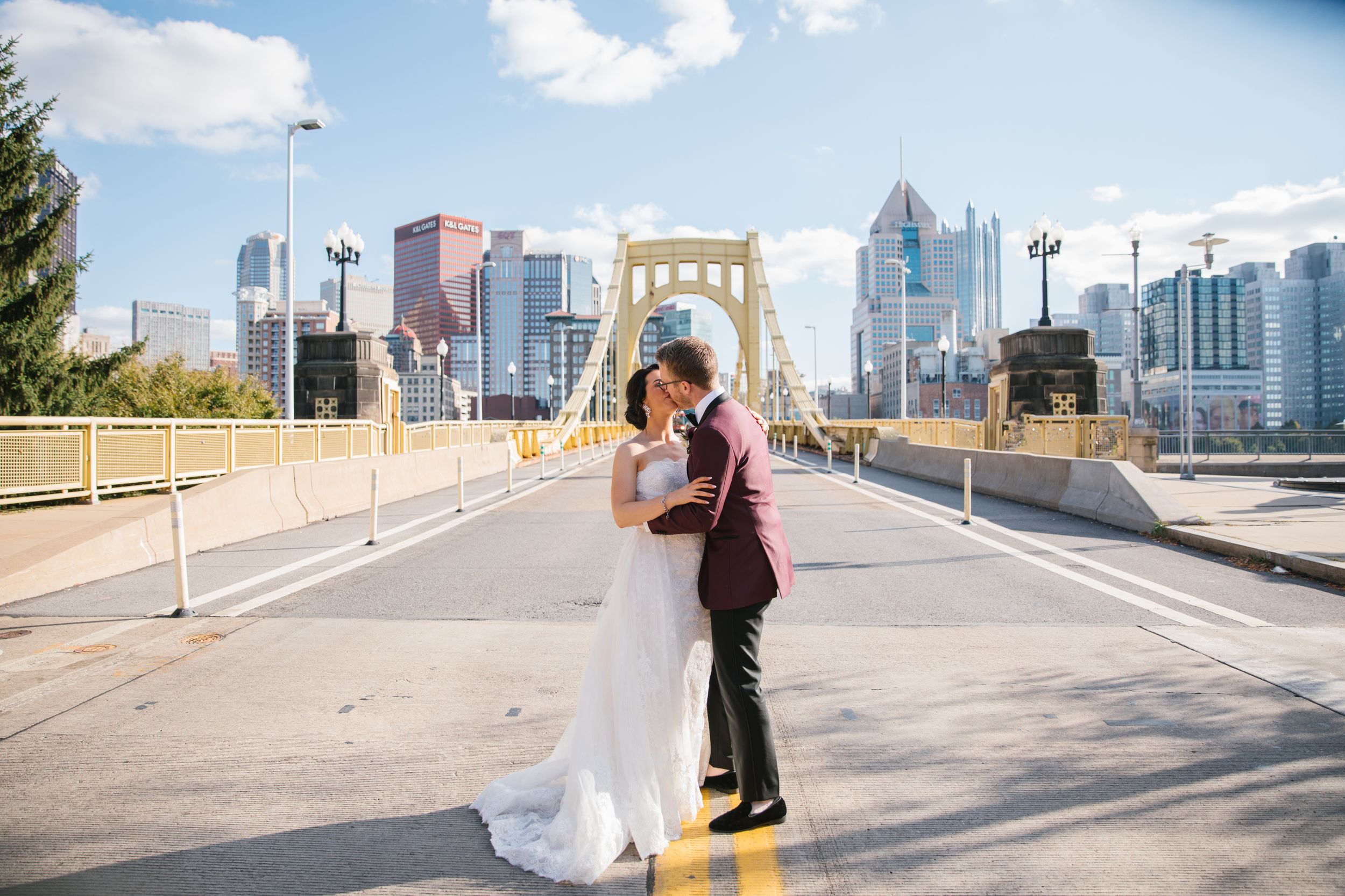 bride and groom kiss on yellow bridge in pittsburgh