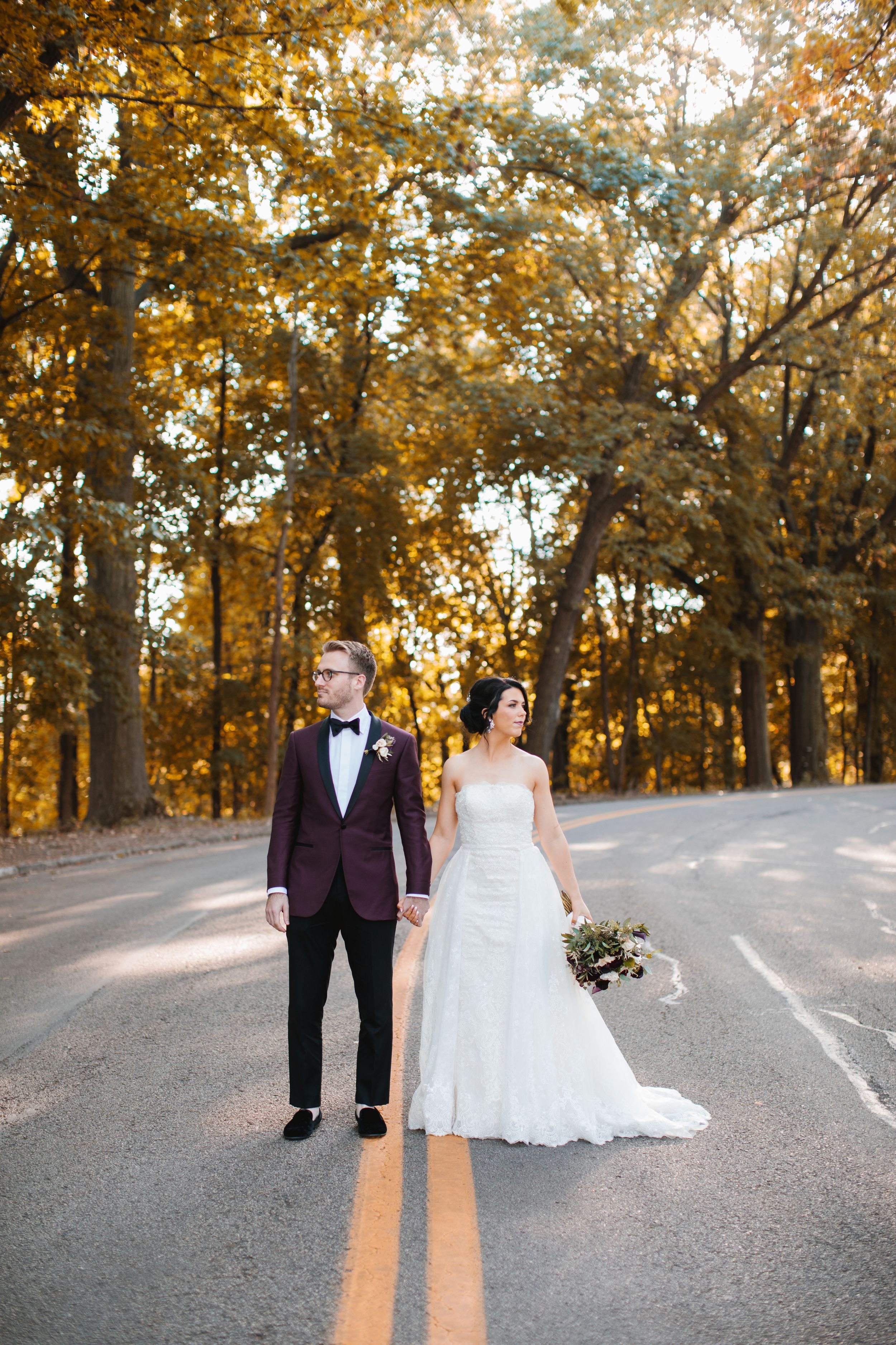 schenley park in the fall bride and groom holding hands and looking in opposite directions