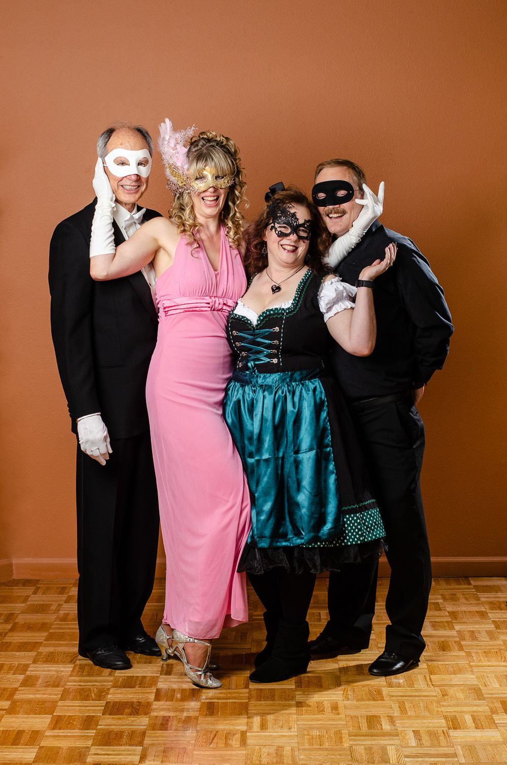 Two couples in costume posing against a wall.