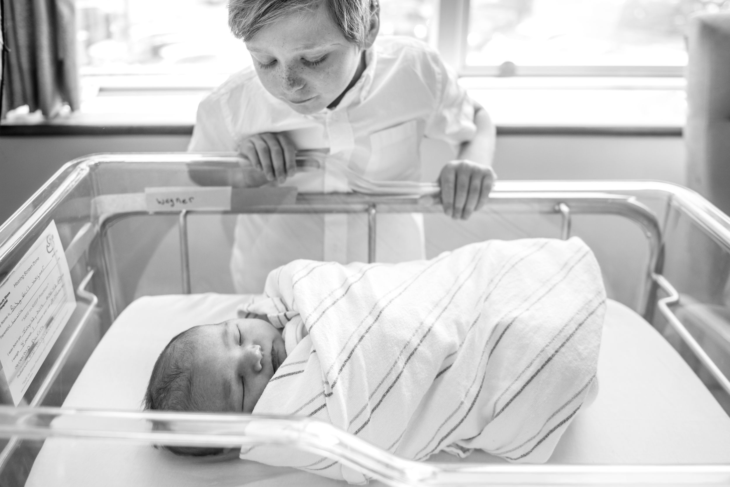 Fresh 48 session captures big brother gazing at new baby in the hospital