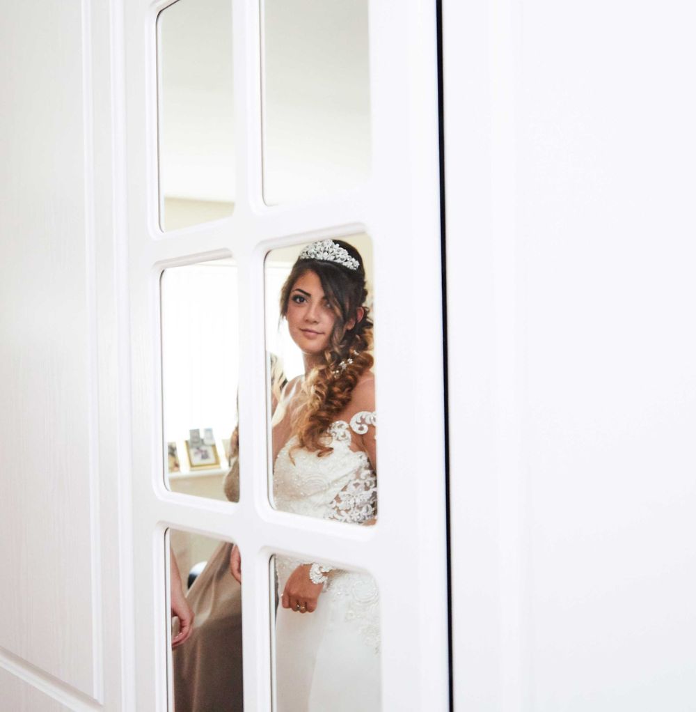 Bride looking through mirror