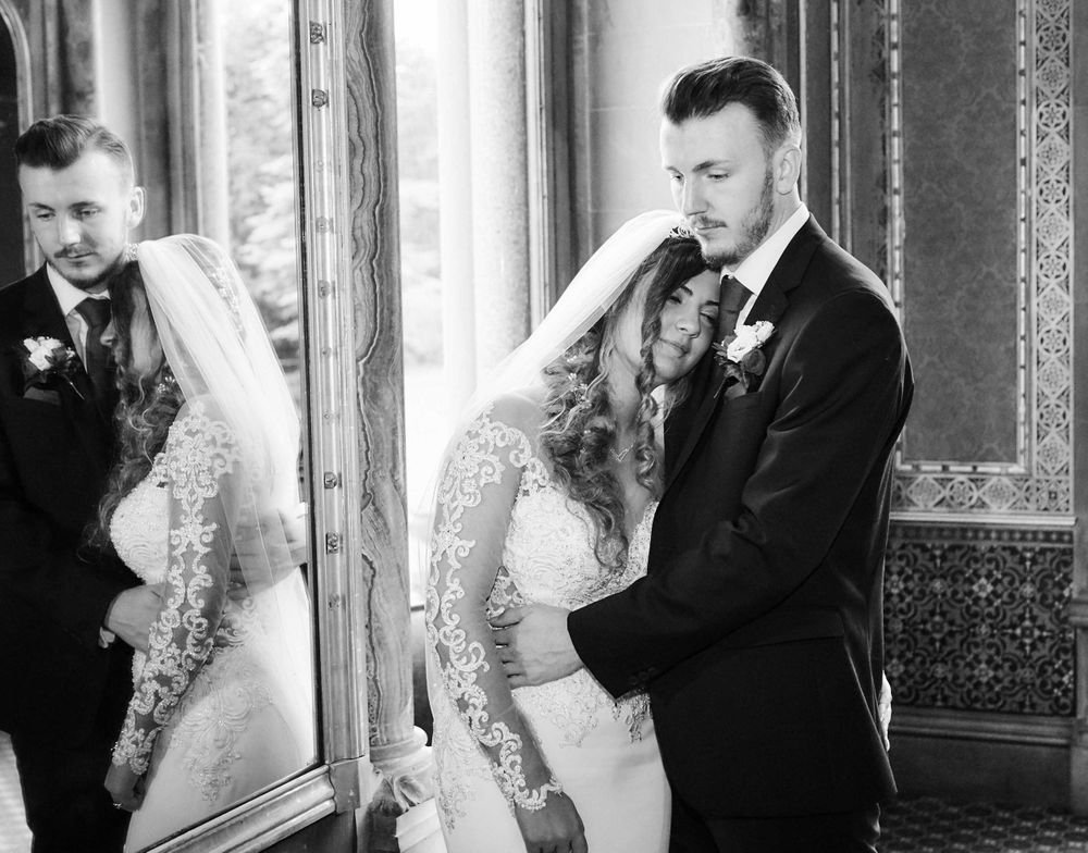Black and white photo of bride and groom with mirror refelction