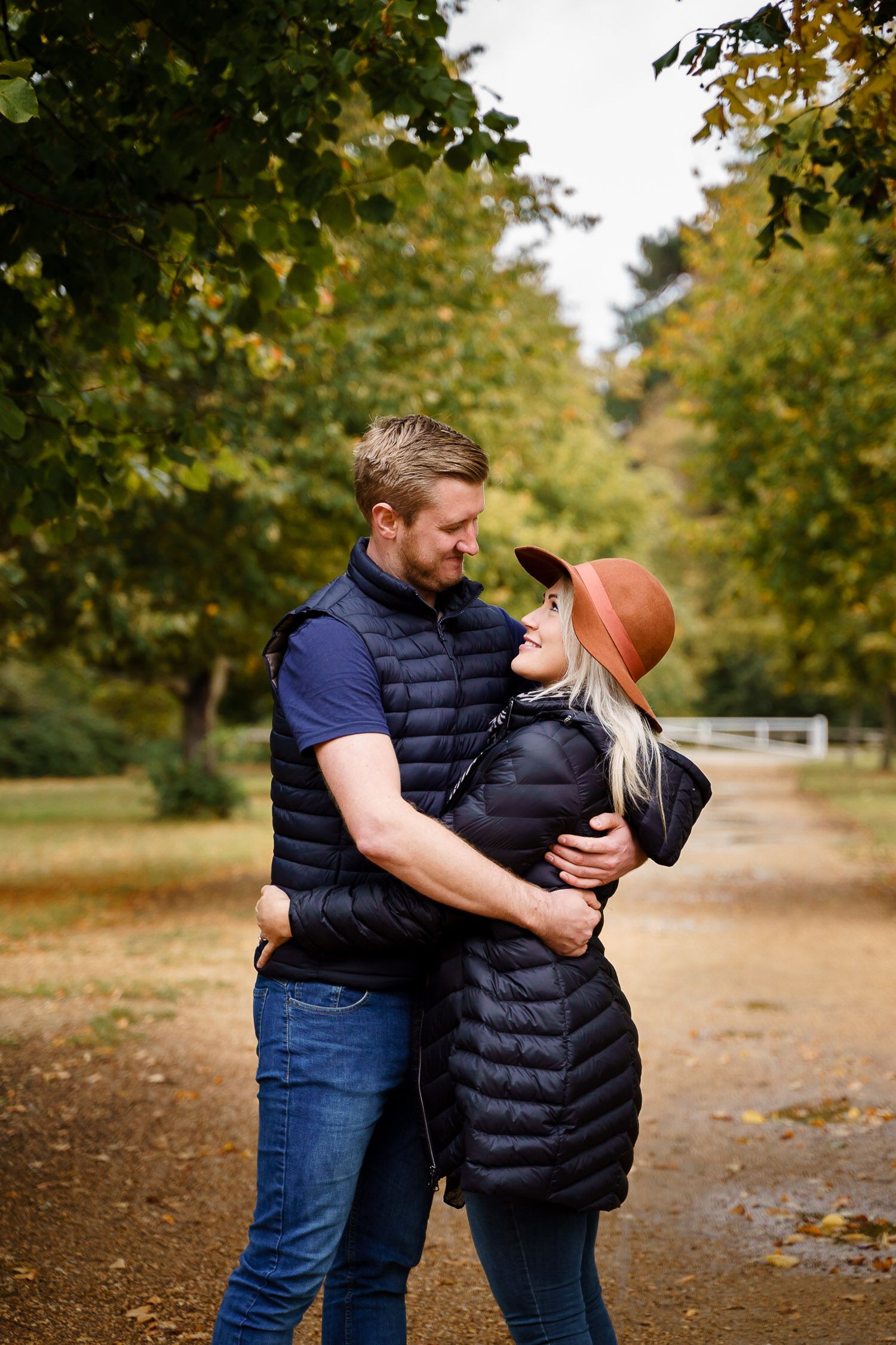 A heterosexual couple cuddle in a local park in autumn. Katherine and her Camera engagement photoshoot.