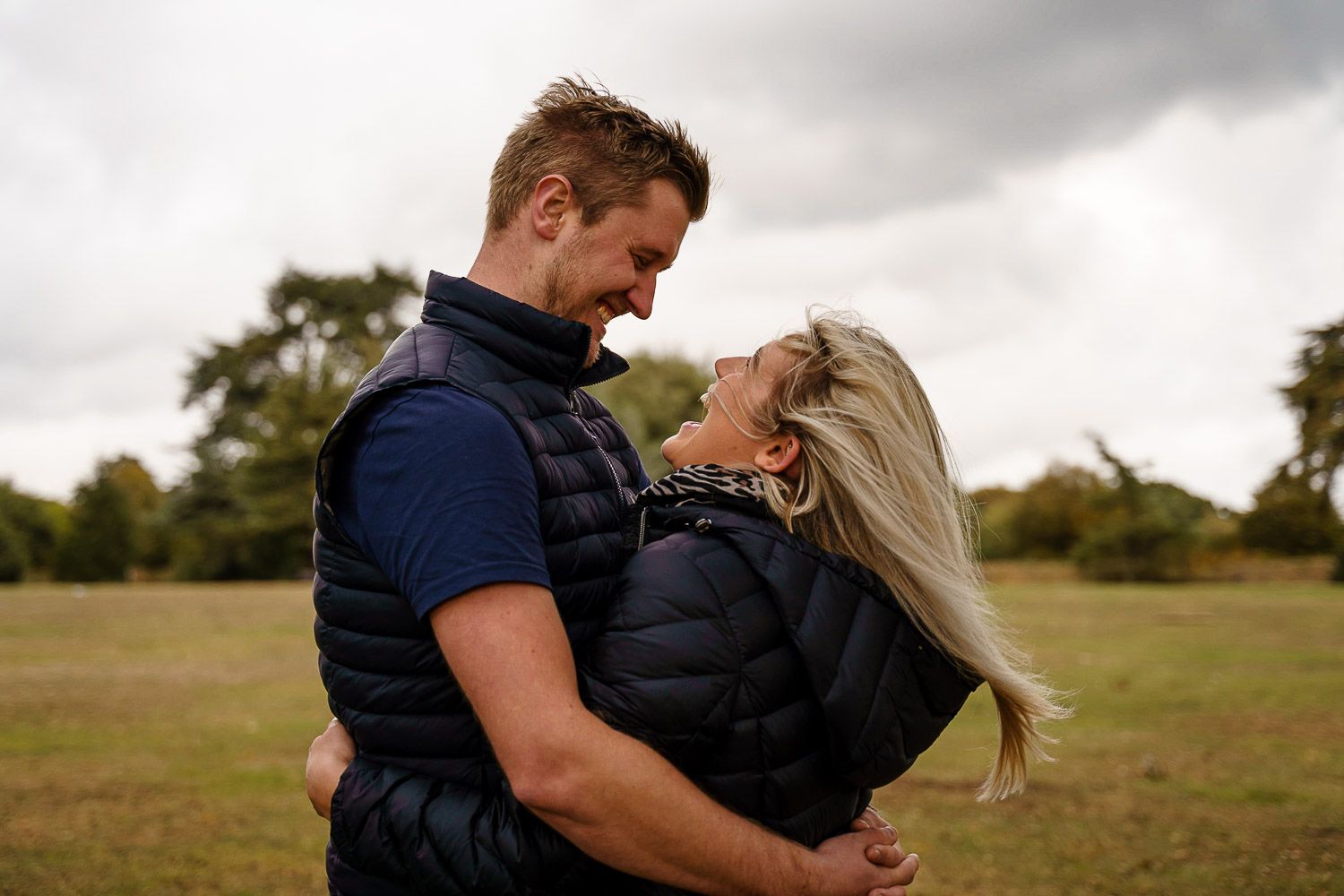 Couple laugh together and cuddle in a park in autumn. Katherine and her Camera engagement photoshoot.