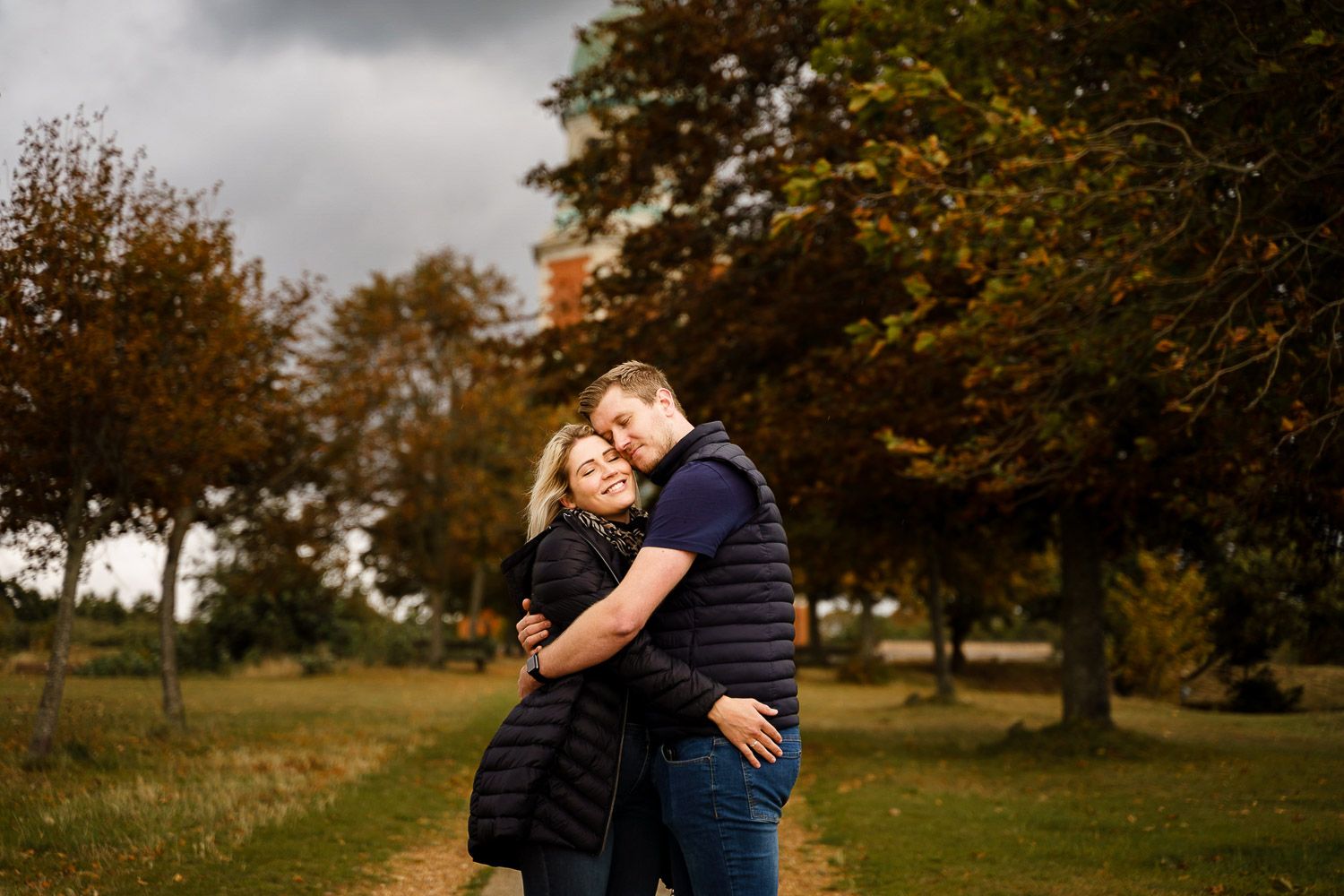 Couple have a cuddle and look out to sea in front of Netley Chapel. Katherine and her Camera engagement photoshoot.