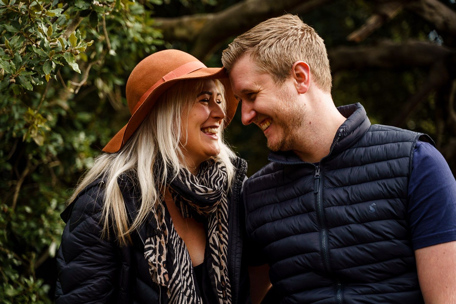 Close up of a couple cuddling up and laughing together in a local park in autumn. Katherine and her Camera