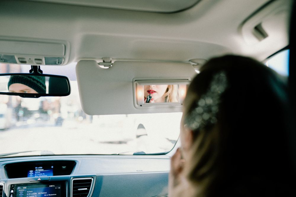 bride-putting-makeup-on-in-car-desmoines-iowa-raelyn-ramey-photography