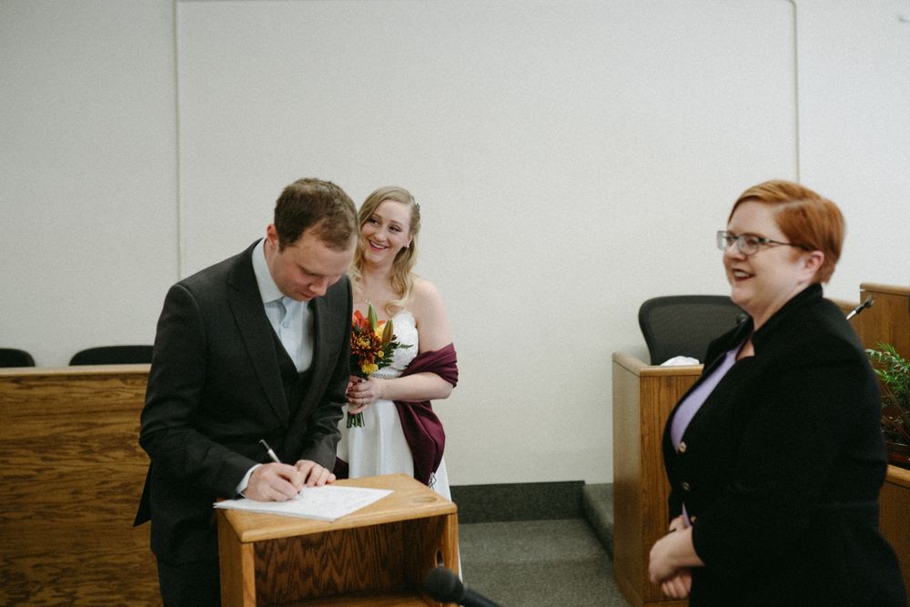 bride-groom-sign-papers-elopement-polk-county-courthouse-desmoines-iowa-raelyn-ramey-photography