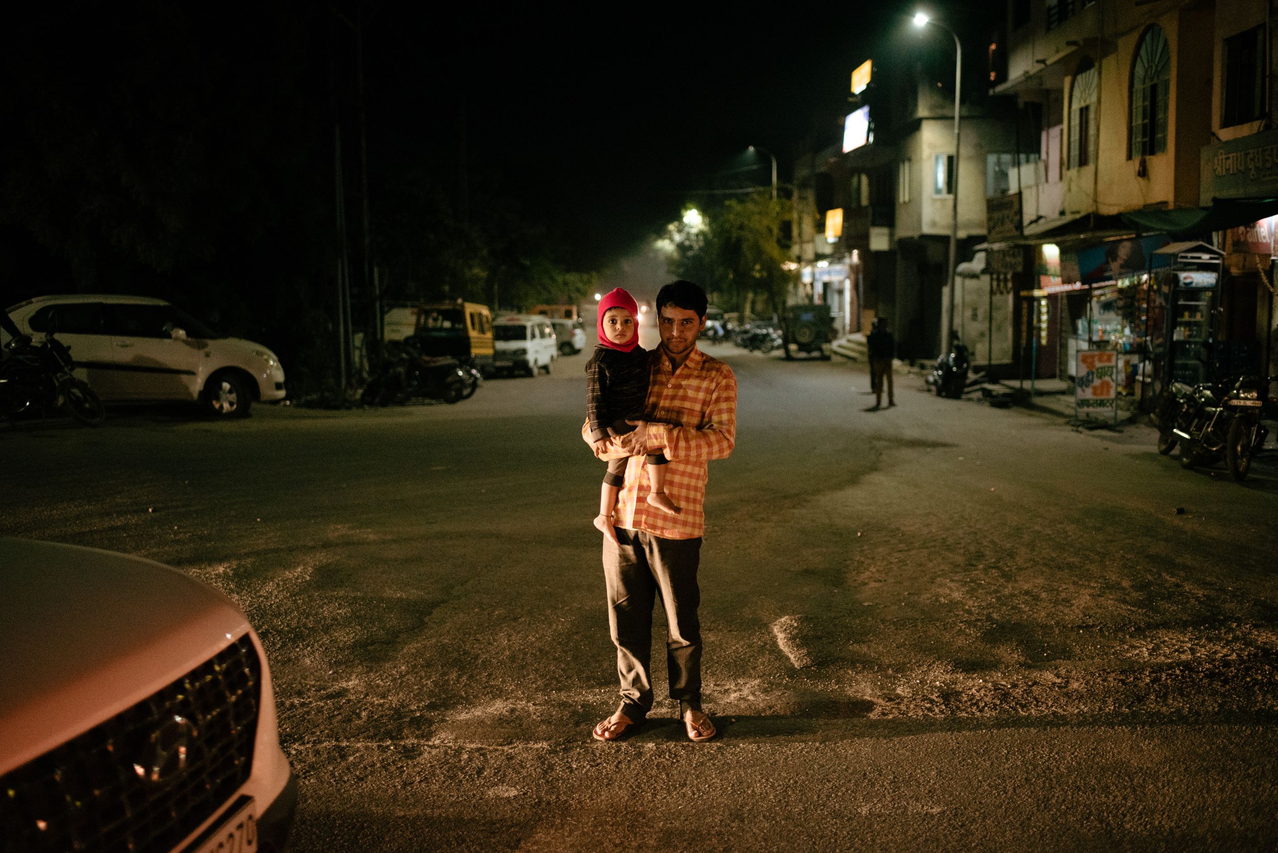 Father and child in headlights, Udaipur, India.
