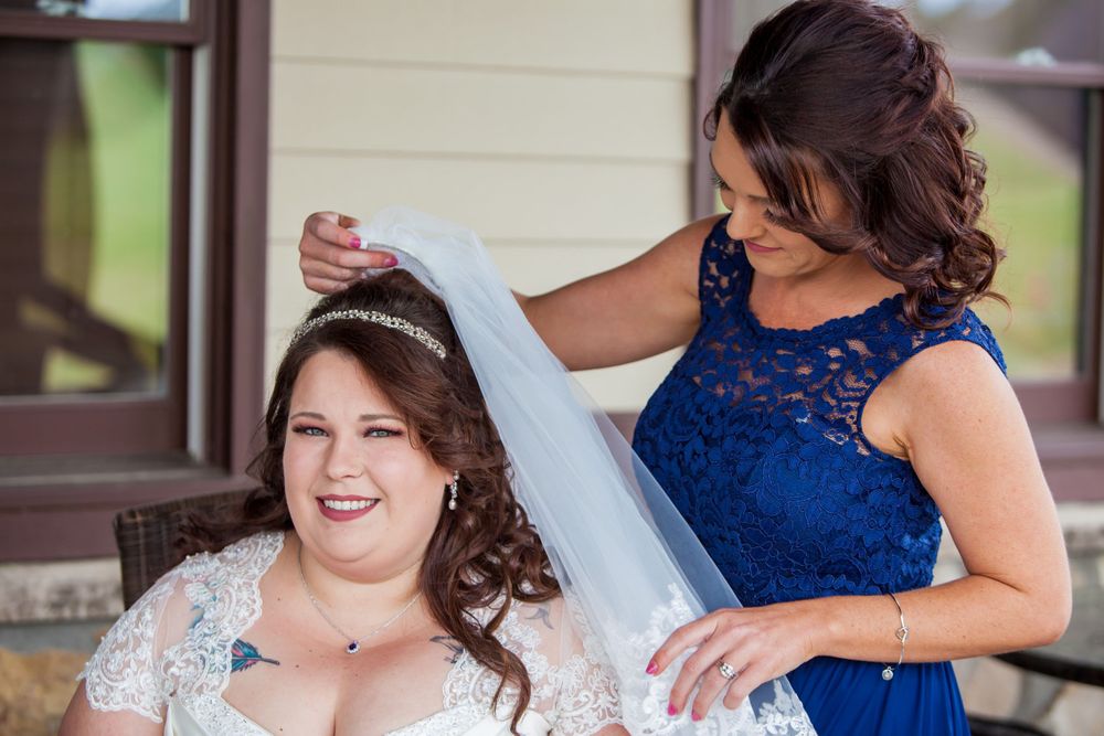 Bridesmaid puts the veil on the bride before a wedding at the Farm at Ridgeway in Ridgeway, SC