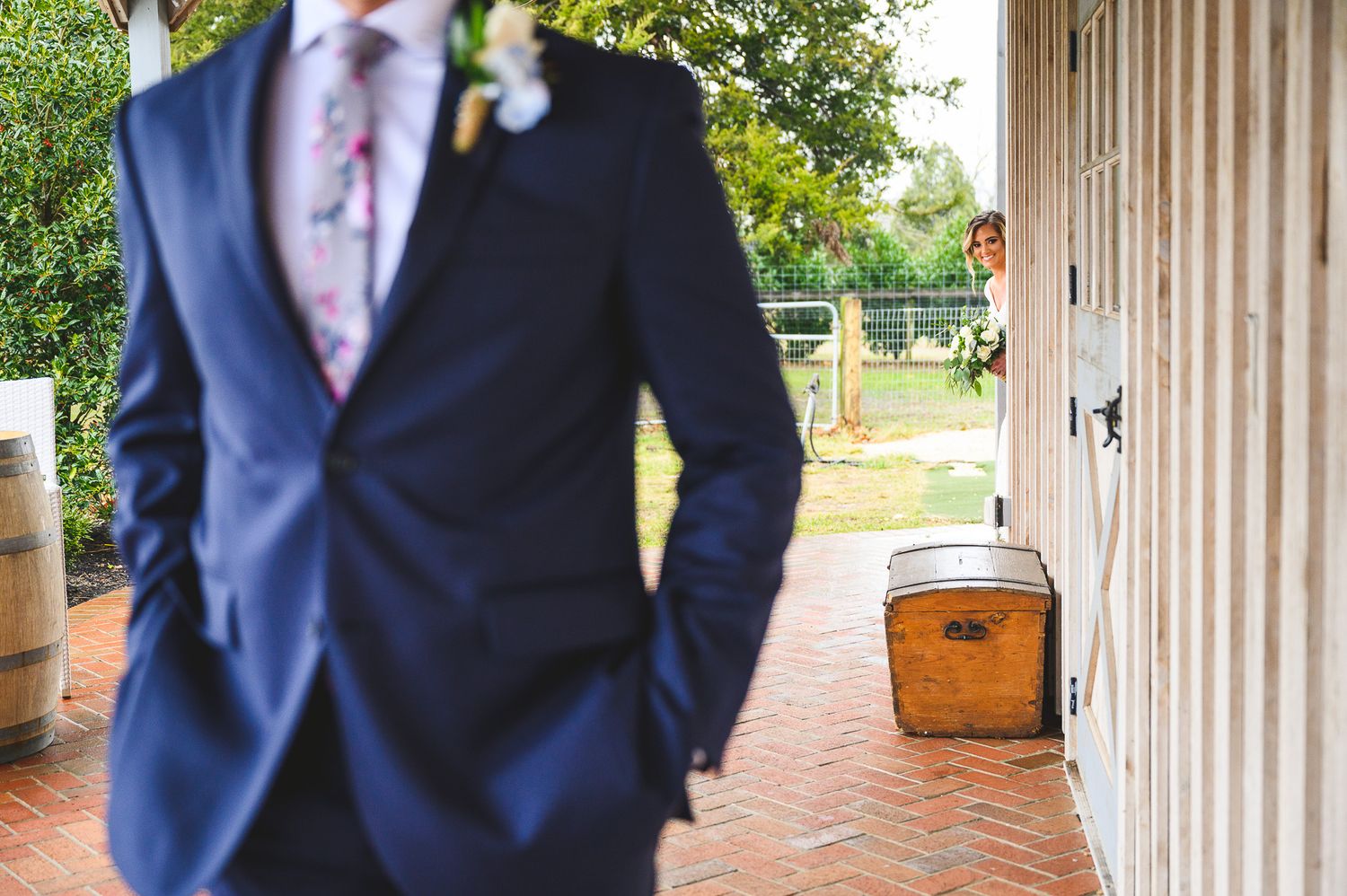 bride peeking out at groom during the first look