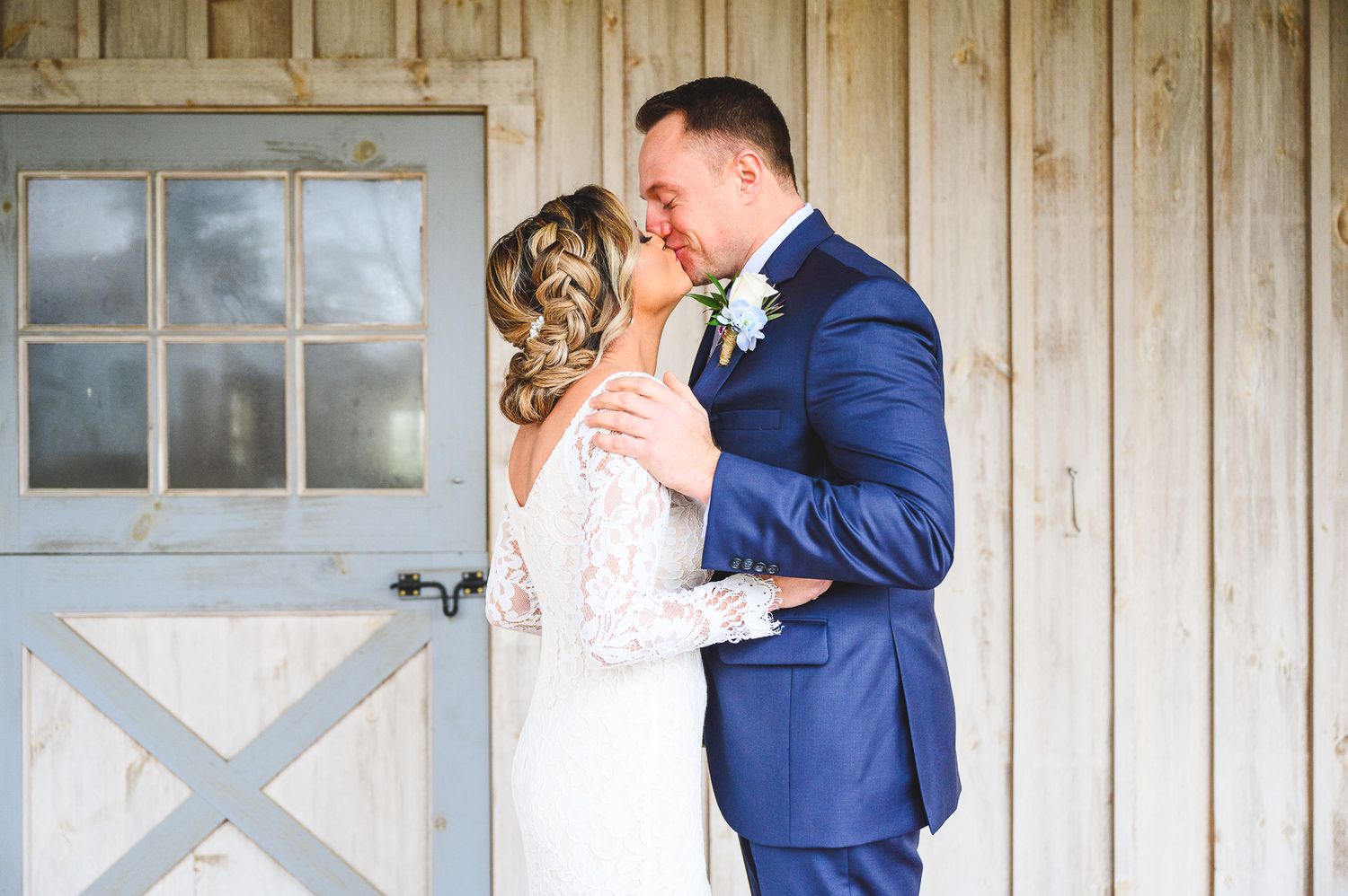 bride and groom kissing and holding each other during the first look